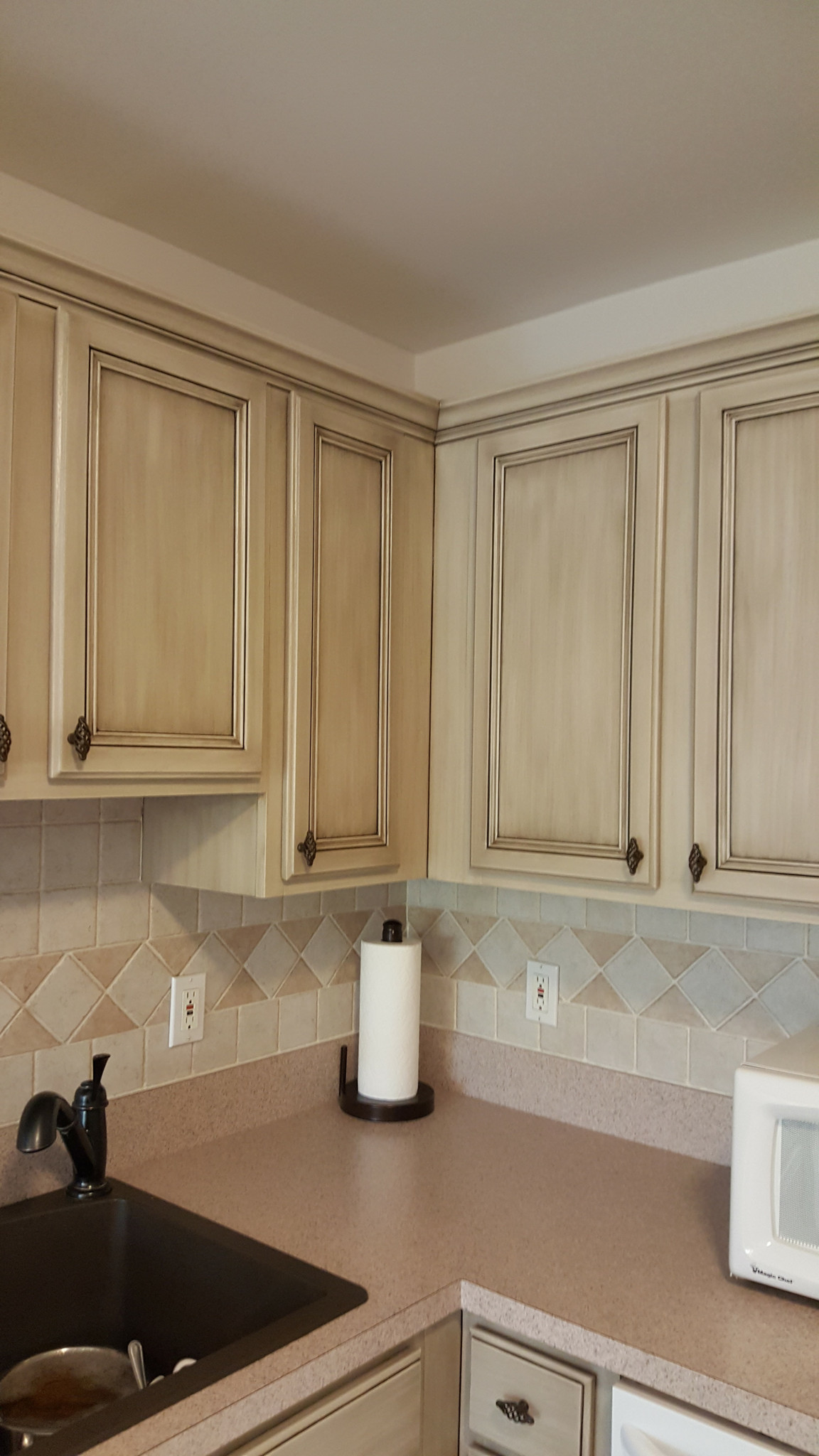 Antiqued cabinets with tile backsplash