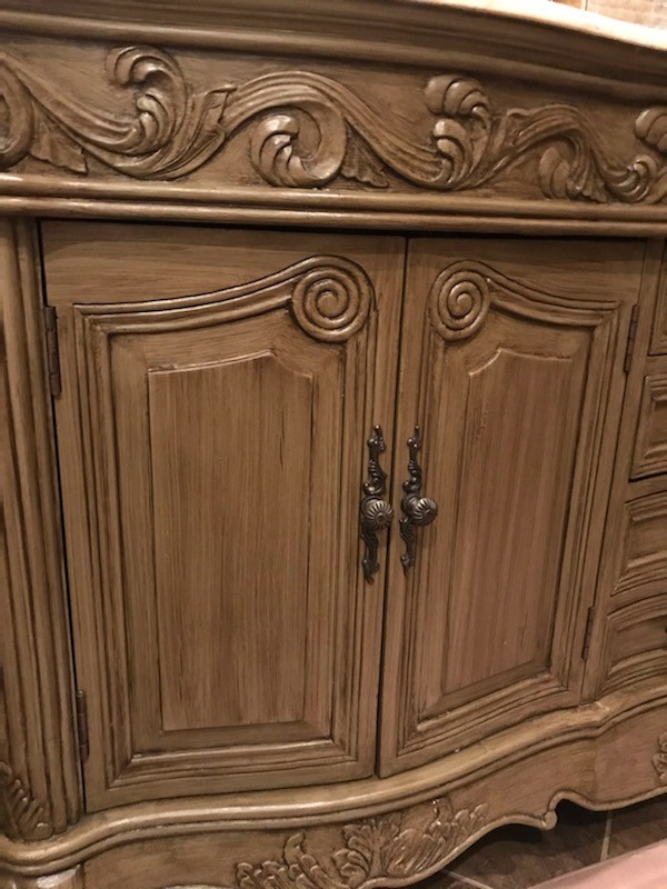 Cabinet doors and carved trim with antiqued finish, before refinishing.