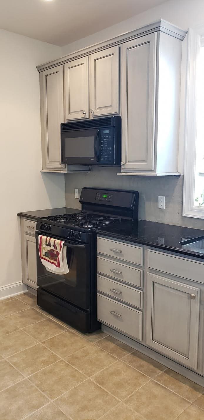 Kitchen cabinet doors and drawer fronts refinished with light gray paint and antiquing glaze.