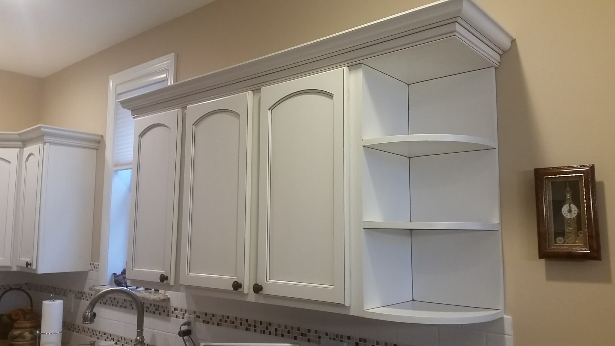 Kitchen upper cabinets, crown molding, and open shelves painted off-white