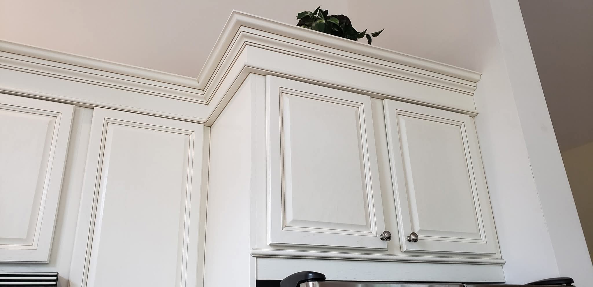 Off-white kitchen cabinet doors and crown molding with light antiquing finish.