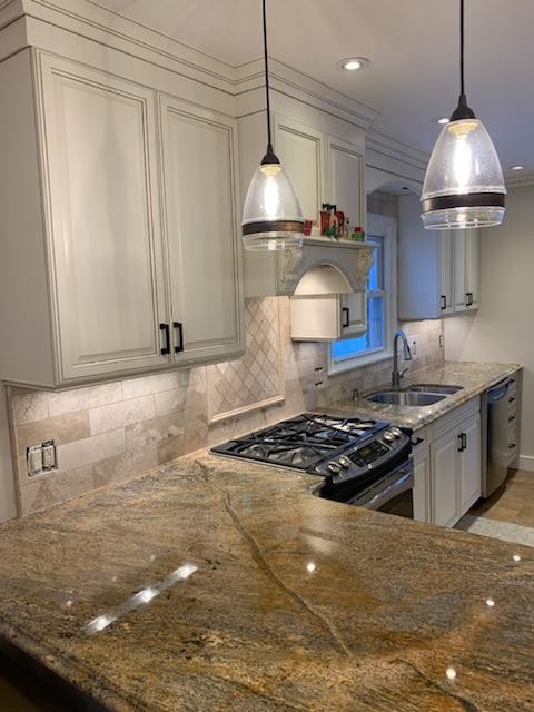 Off-white kitchen cabinet doors and drawers after refinishing with new hardware.