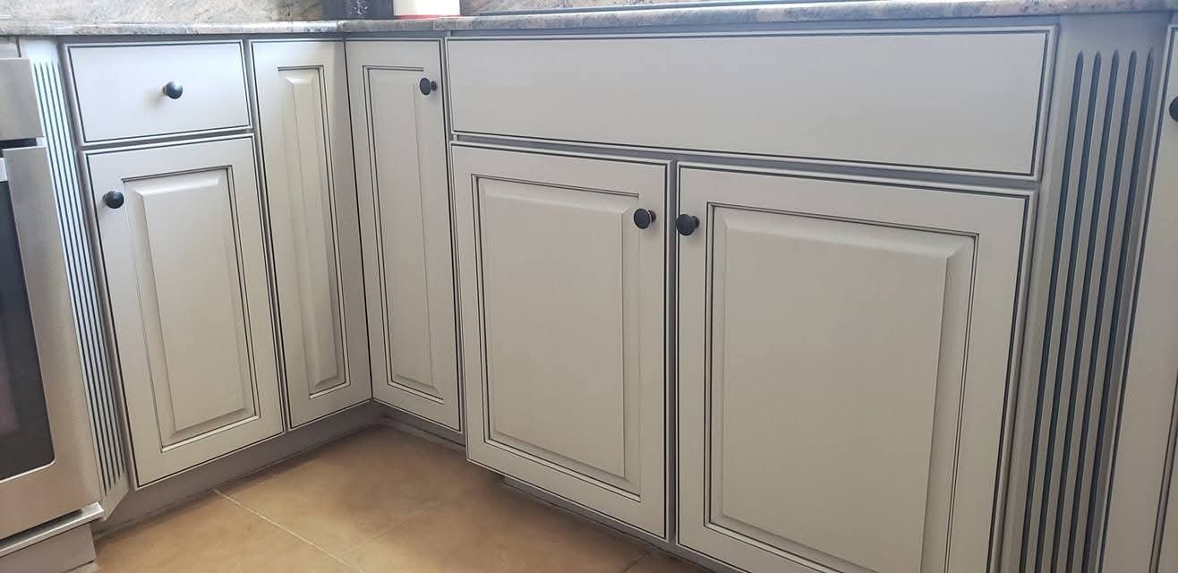 Off-white kitchen cabinet doors and drawers with dark gray glaze finish.