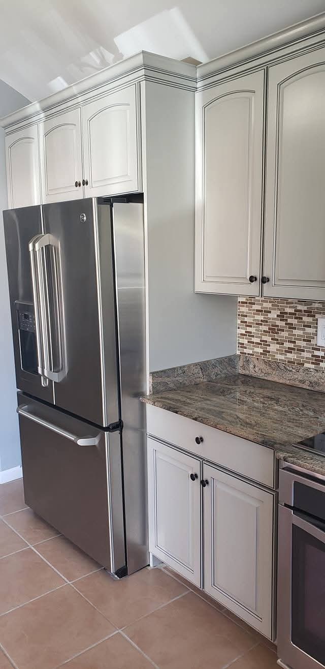 White kitchen cabinet doors, drawer fronts, and crown molding with antiquing technique.