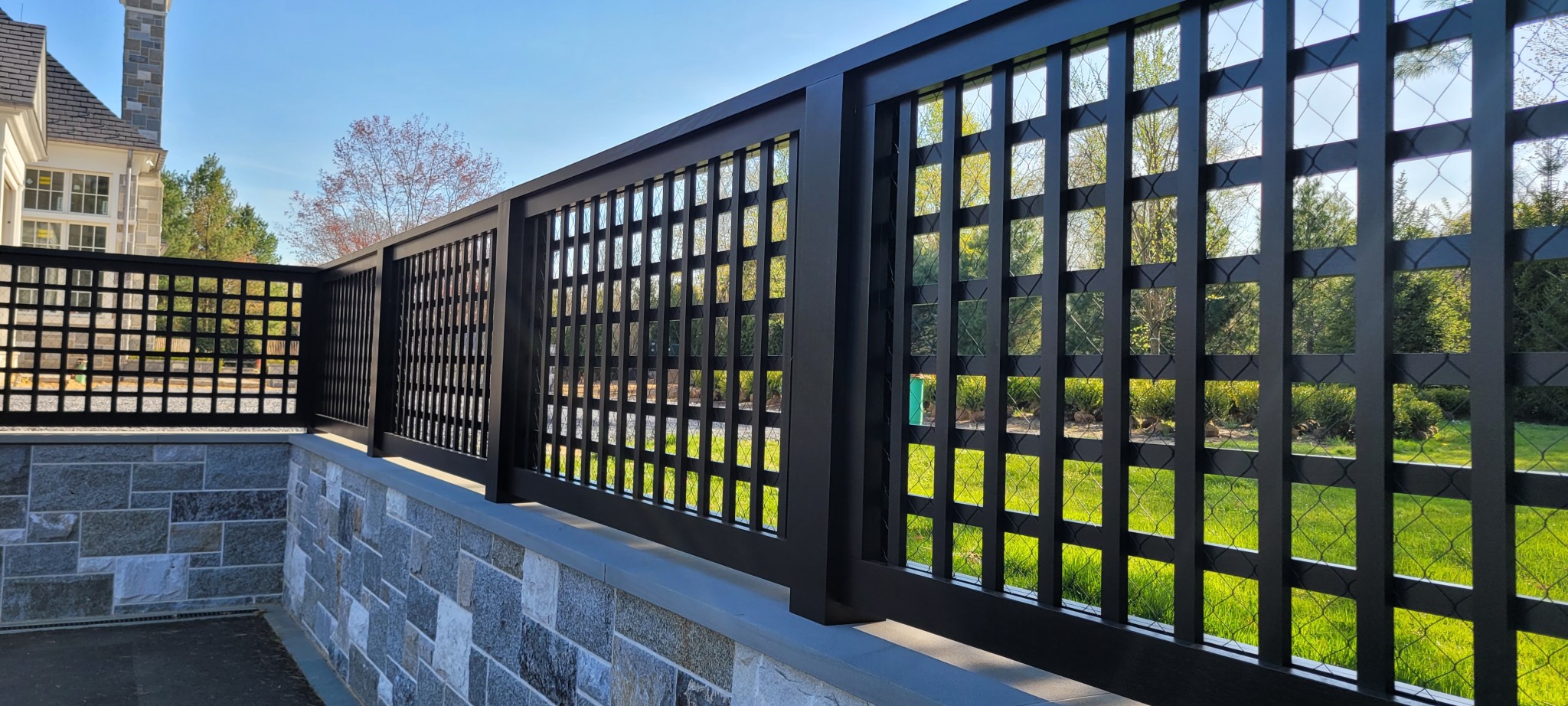 Exterior privacy lattice and trellis painted black for a residential property.