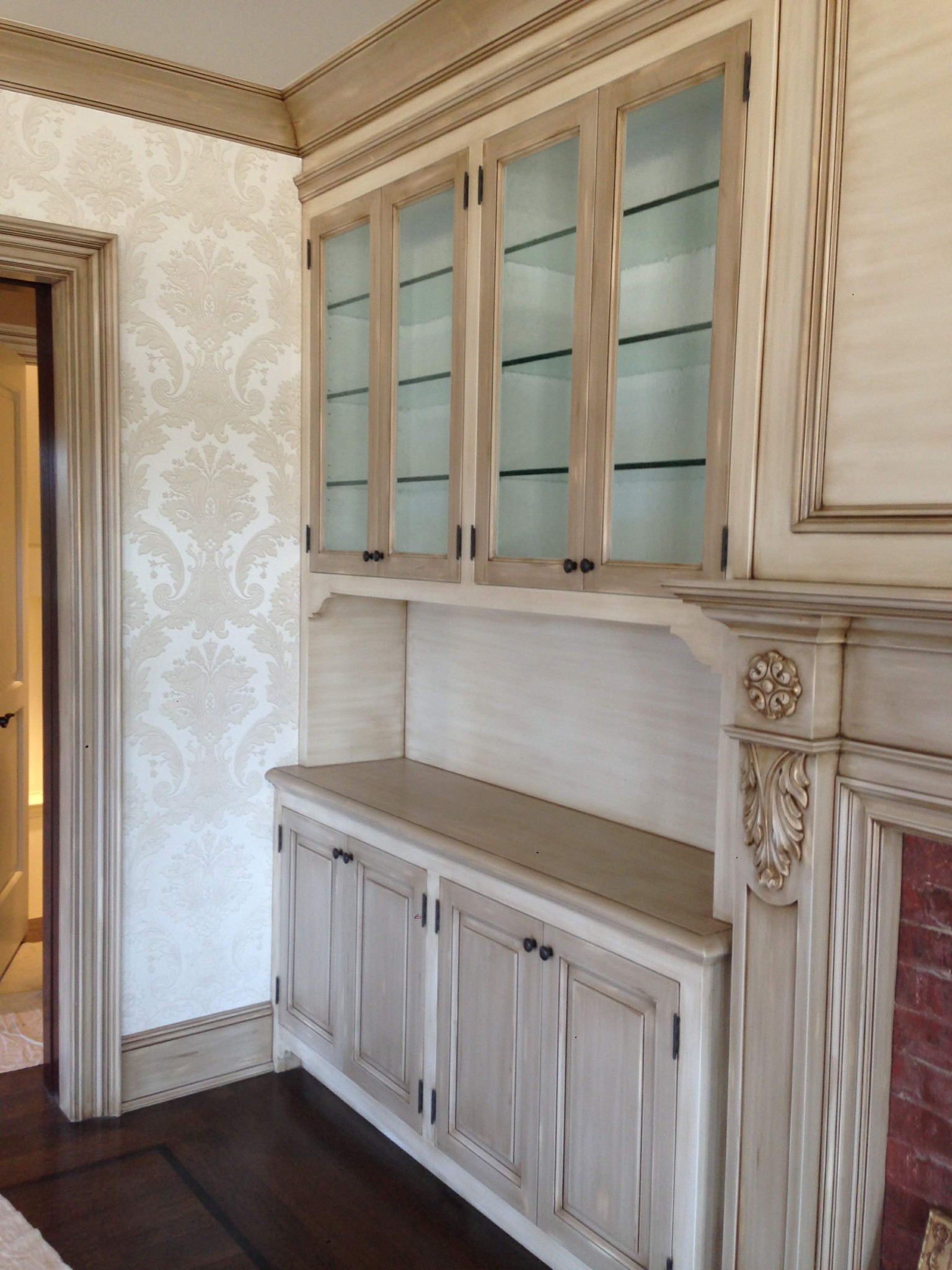 Built-in cabinet, crown molding, and door frame with antiqued finish.