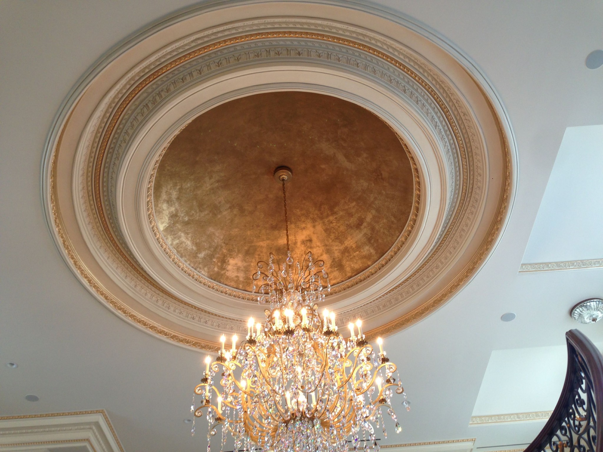 Ceiling medallion and dome with gold leaf technique, painted trim, and white ceiling.