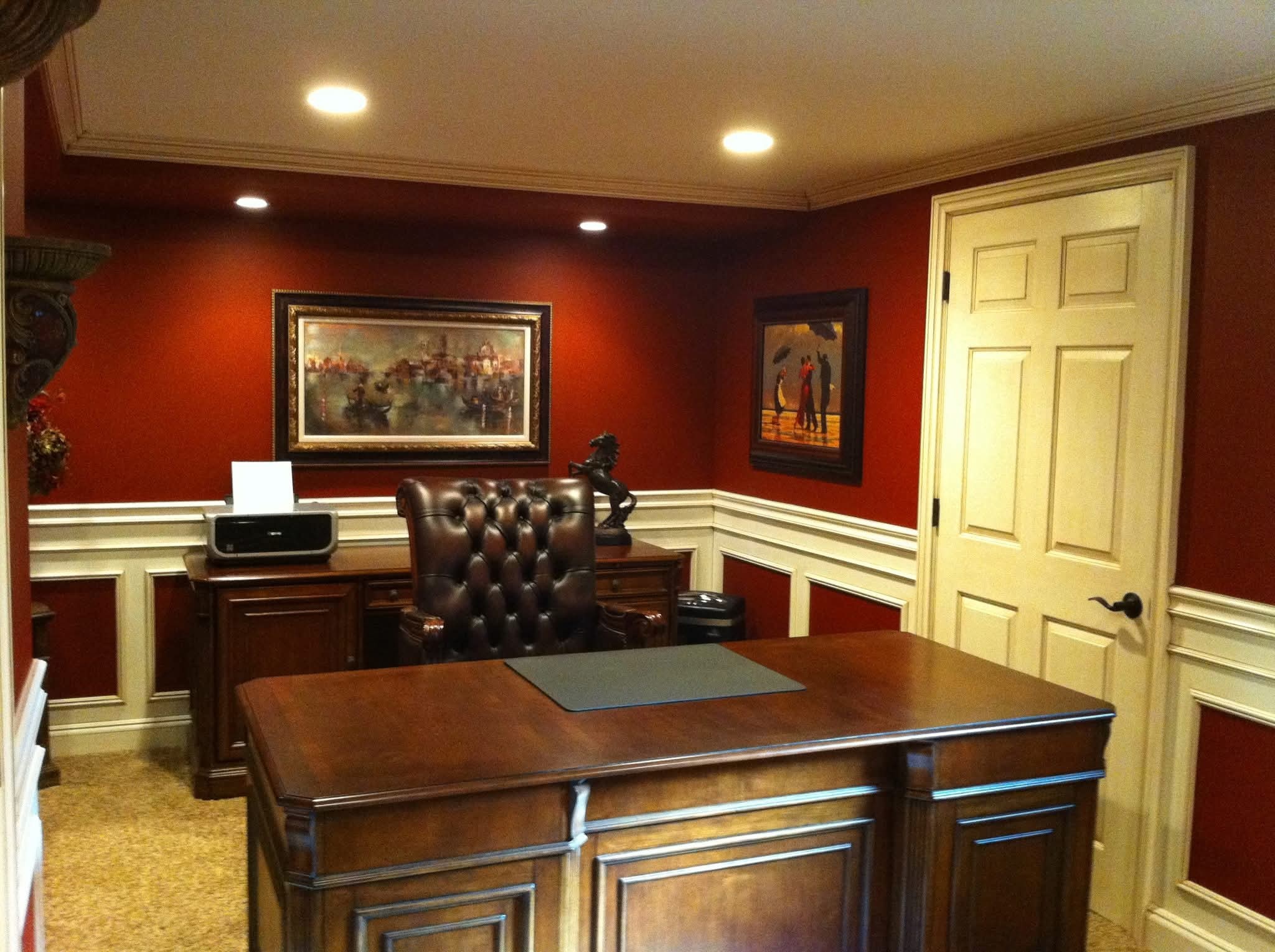 Deep red walls with off-white wainscoting and painted trim in a room.