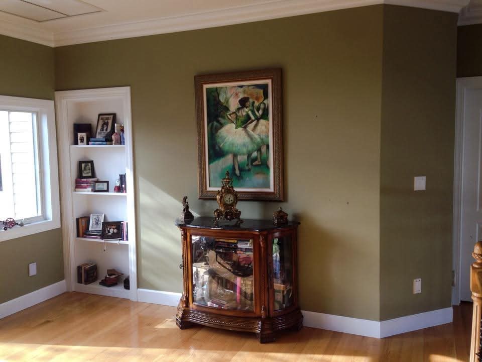 Interior room with olive green walls, white crown molding, and painted baseboards.