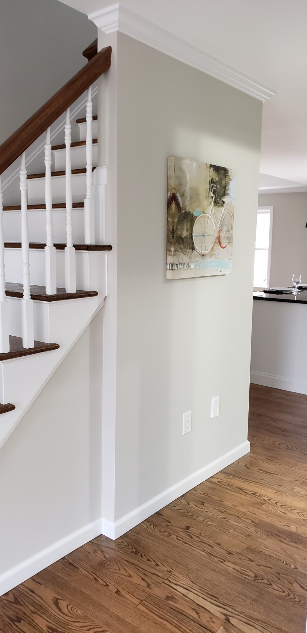 Light gray wall repaint with white trim and staircase balusters.