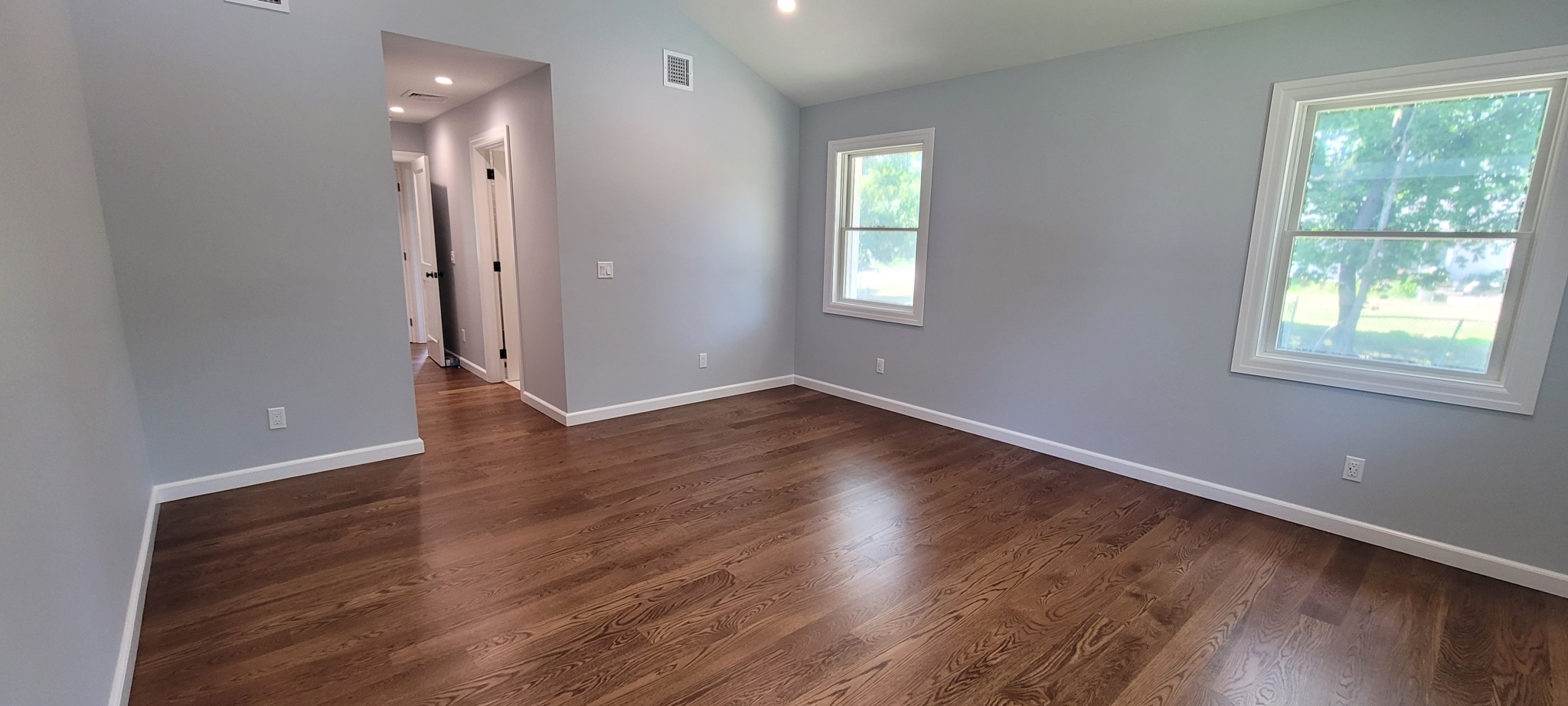 Light gray walls, white baseboards, and window trim in a room.