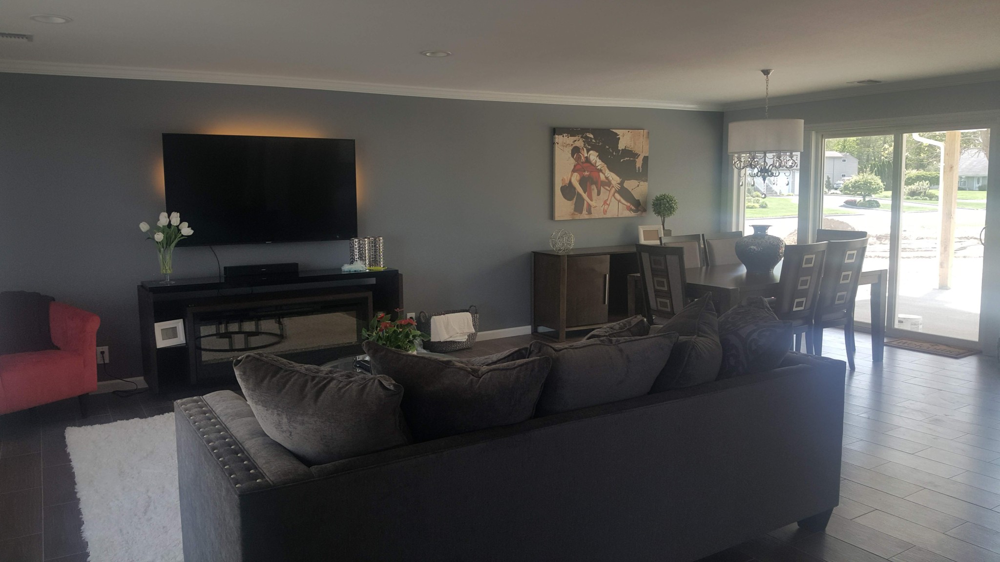 Living and dining area walls painted charcoal gray with white ceilings and crown molding.