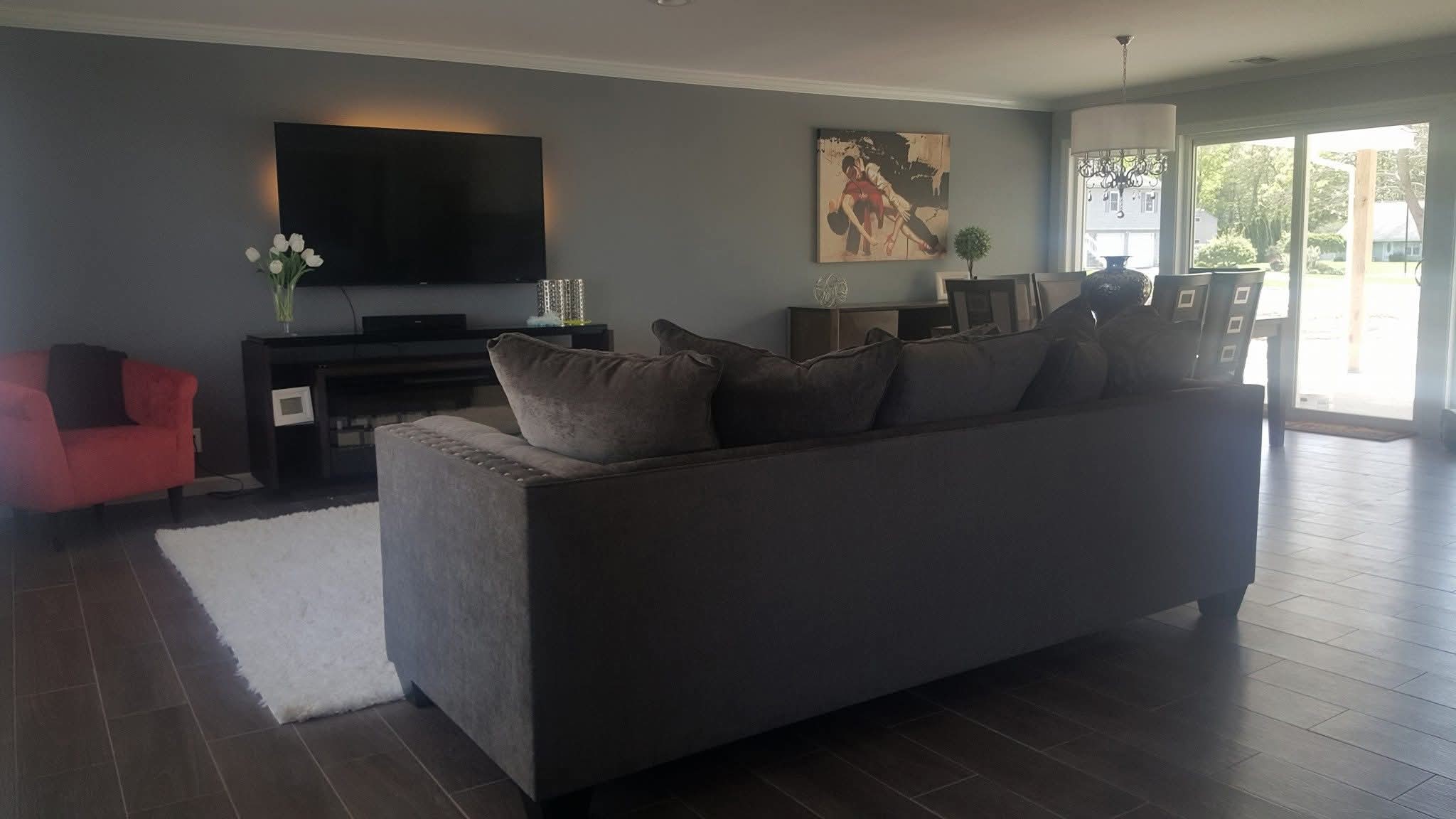 Living room and dining area with recently painted gray walls and white crown molding.