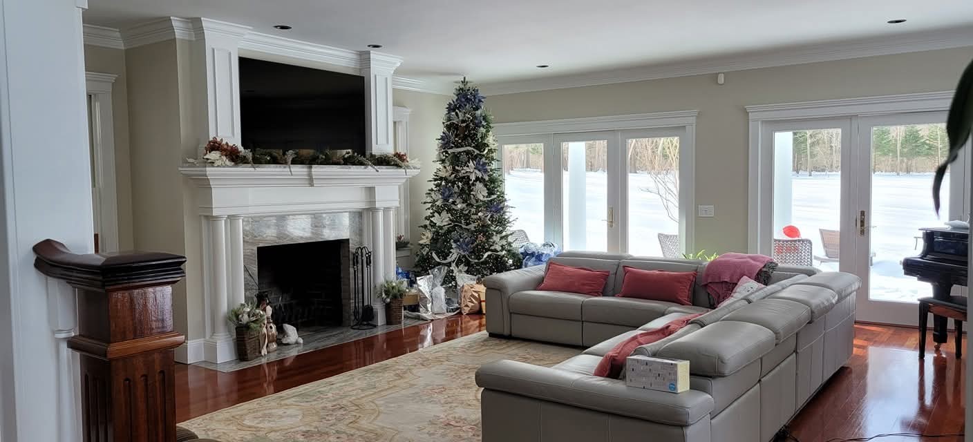 Living room interior with off-white walls, white crown molding, and fireplace surround.