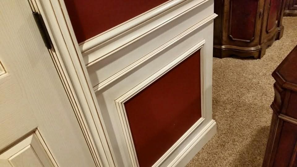 Off-white paneled wainscoting with accent lines and red wall sections.