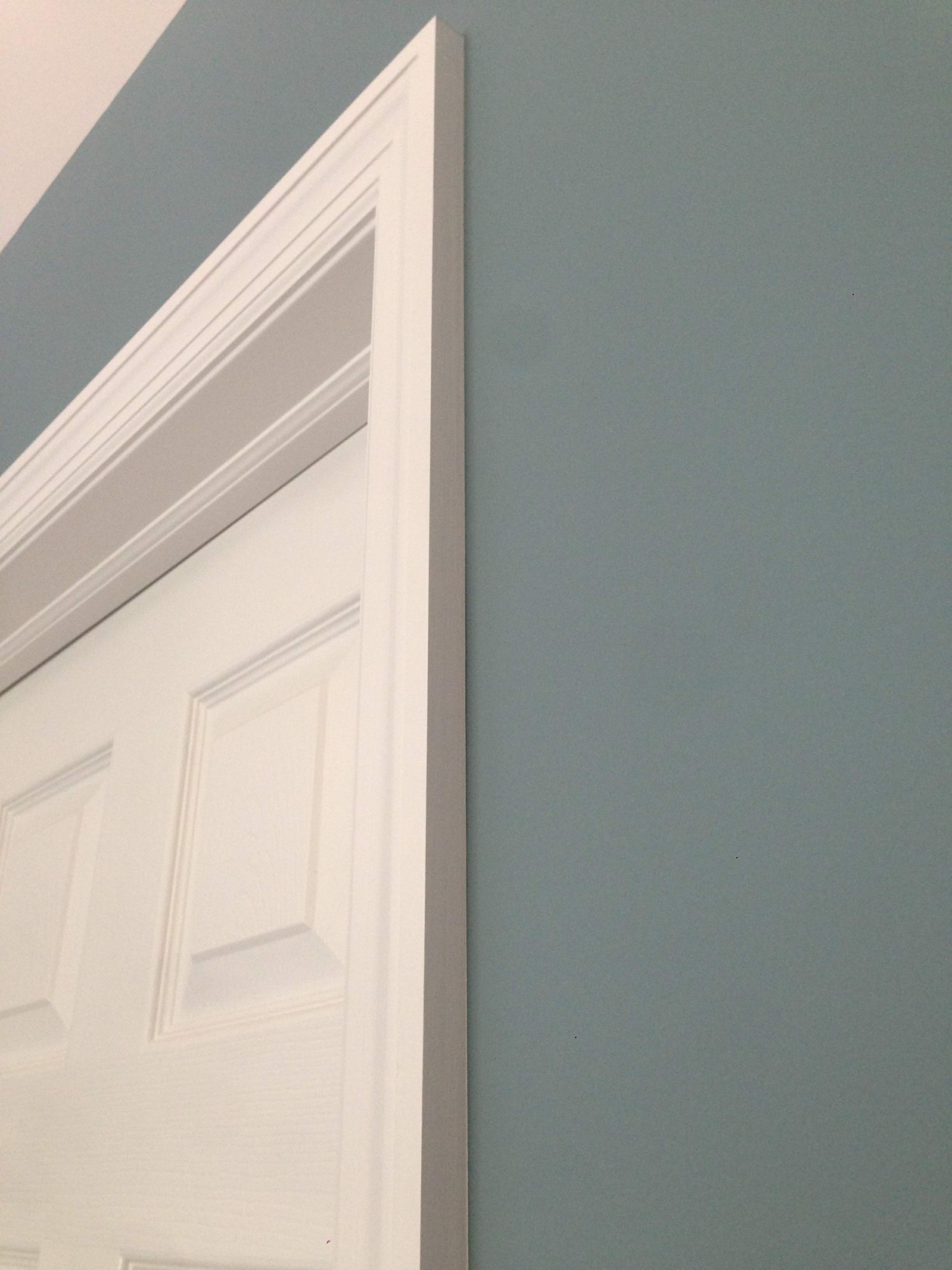 Painted door frame and interior door against a light blue-gray wall.