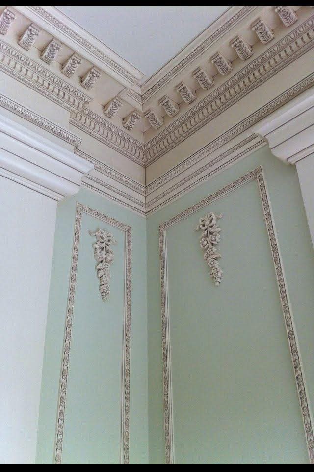 Painted walls and intricate crown moldings with decorative applied wall panels.