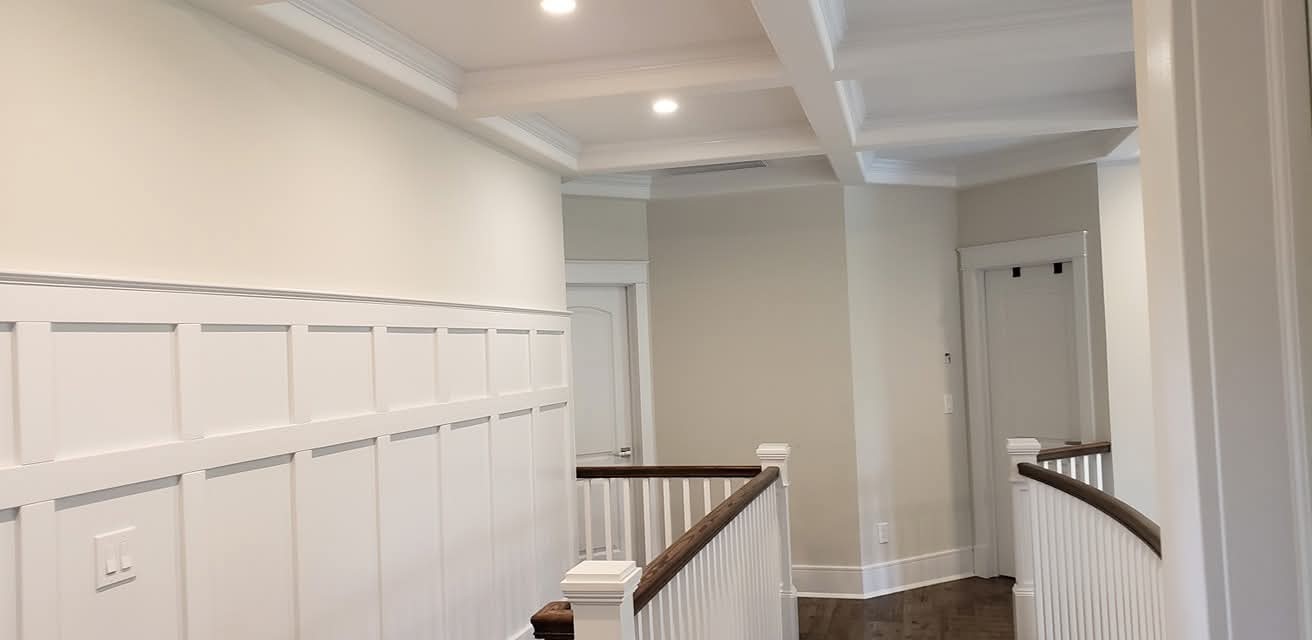 Painted walls, ceiling, crown molding, wainscoting, and stair balusters.