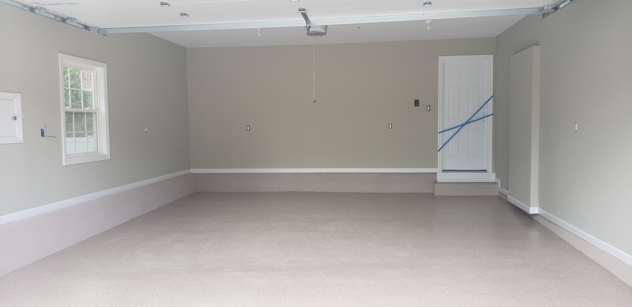 Recently painted garage walls, ceilings, and trim in light gray and white finishes.