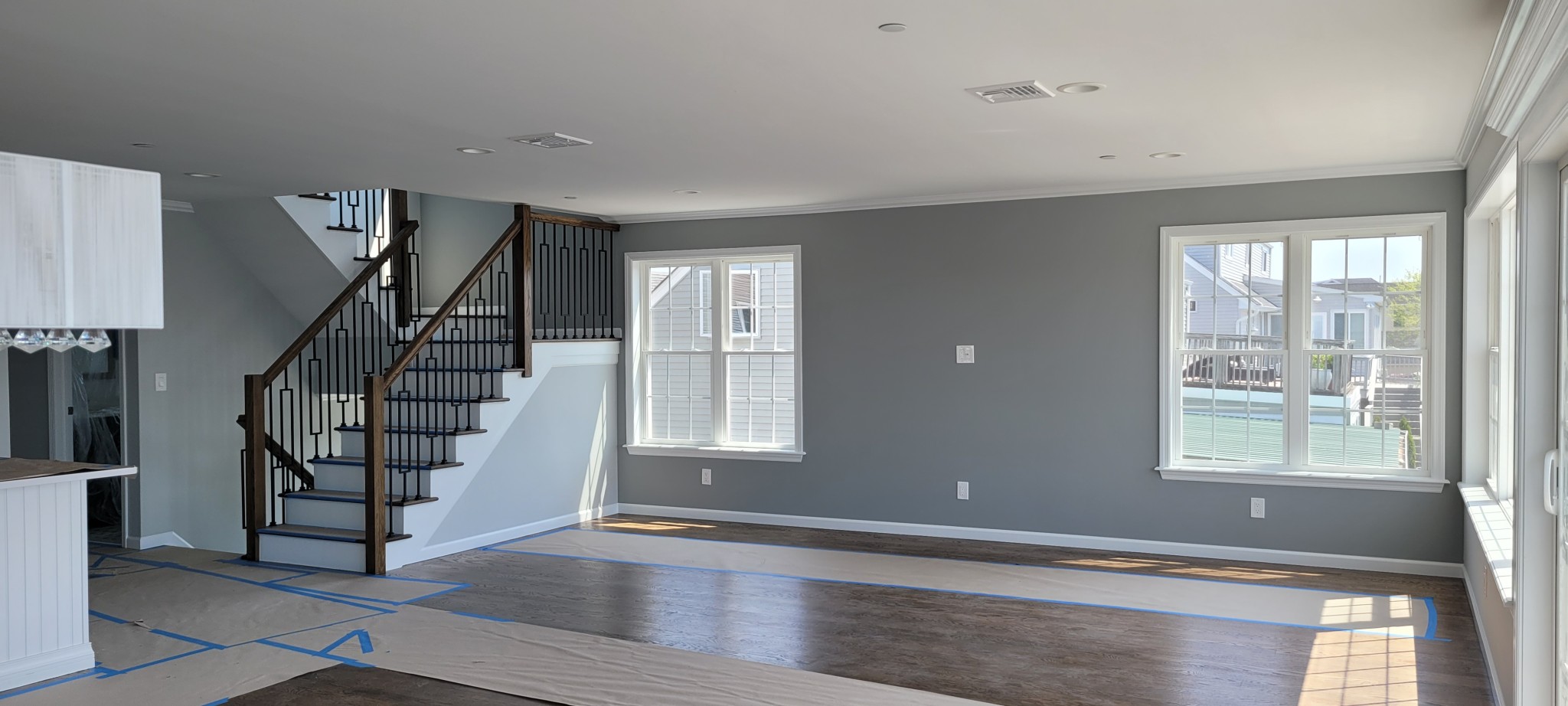 Recently painted interior walls, ceiling, crown molding, and window trim with a staircase.