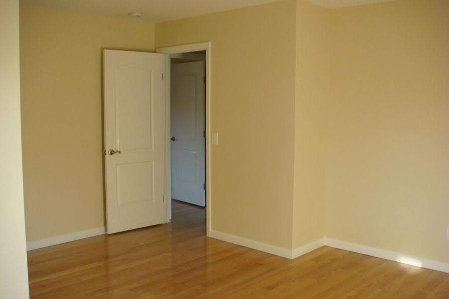 Recently painted off-white walls, white baseboards, and white interior doors.