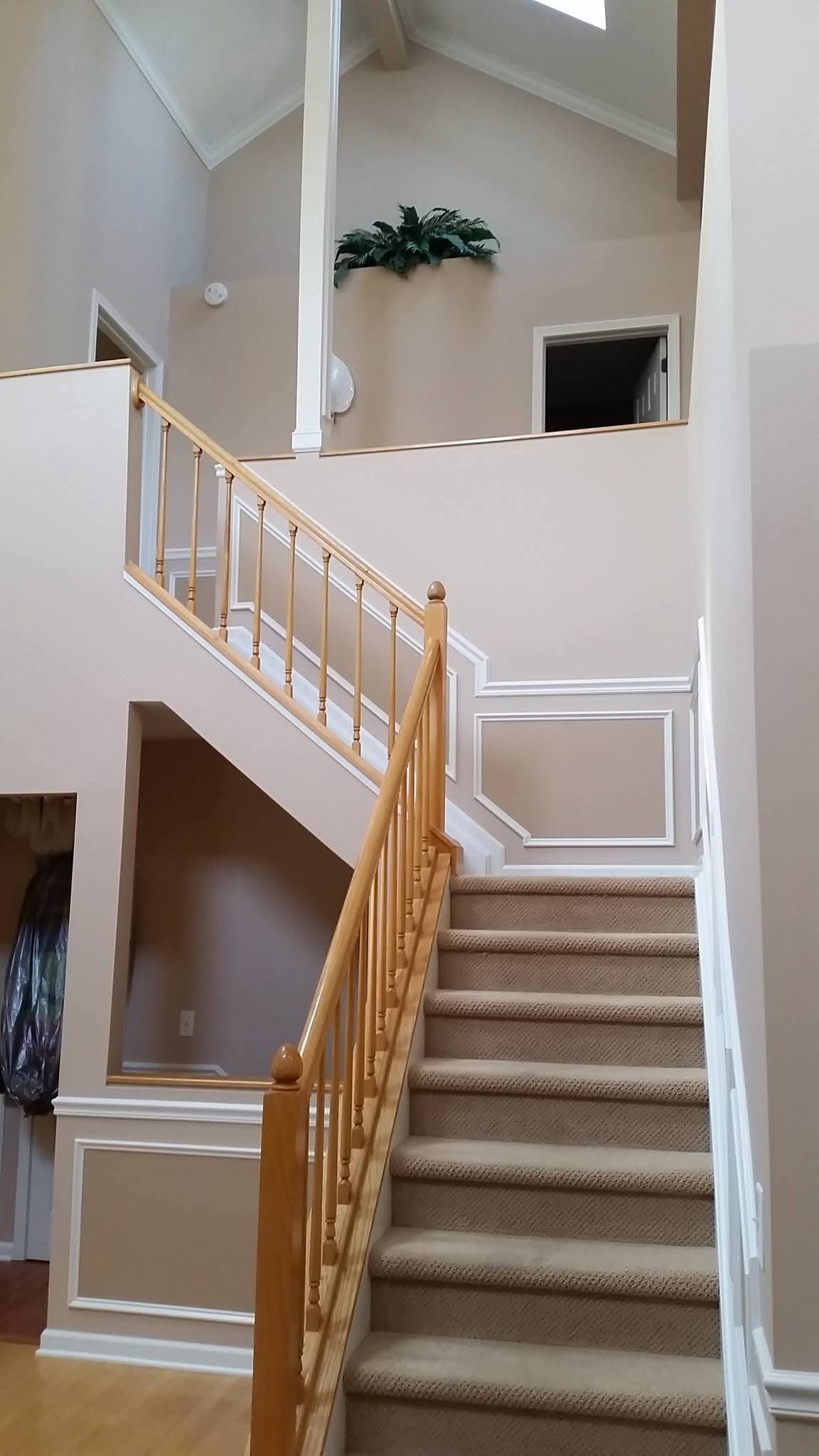 Repainted interior walls and white trim in a staircase and hallway area.
