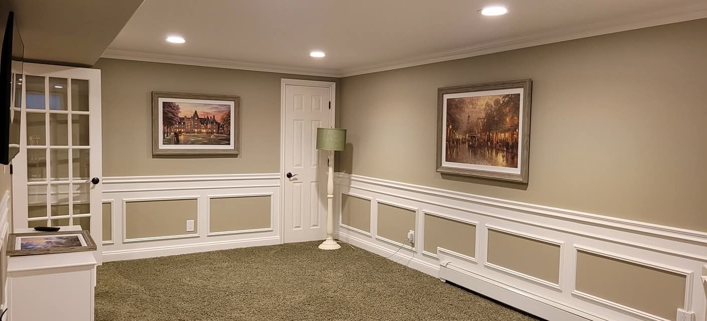 Repainted walls, white wainscoting, and trim in a finished basement room.