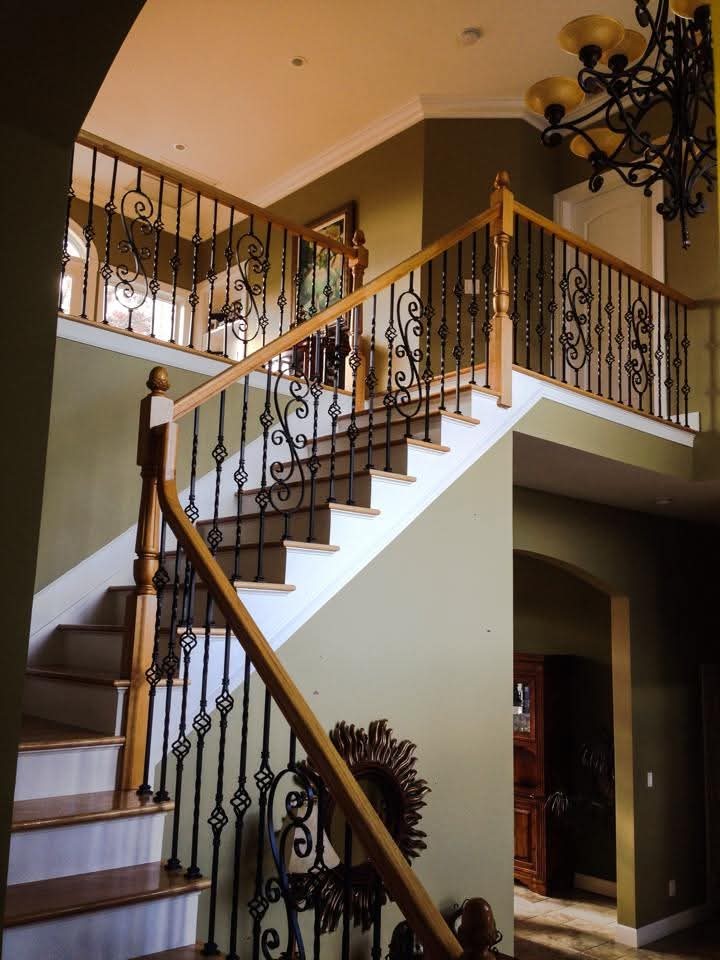 Staircase with painted risers, stringers, and newel posts in an entryway.