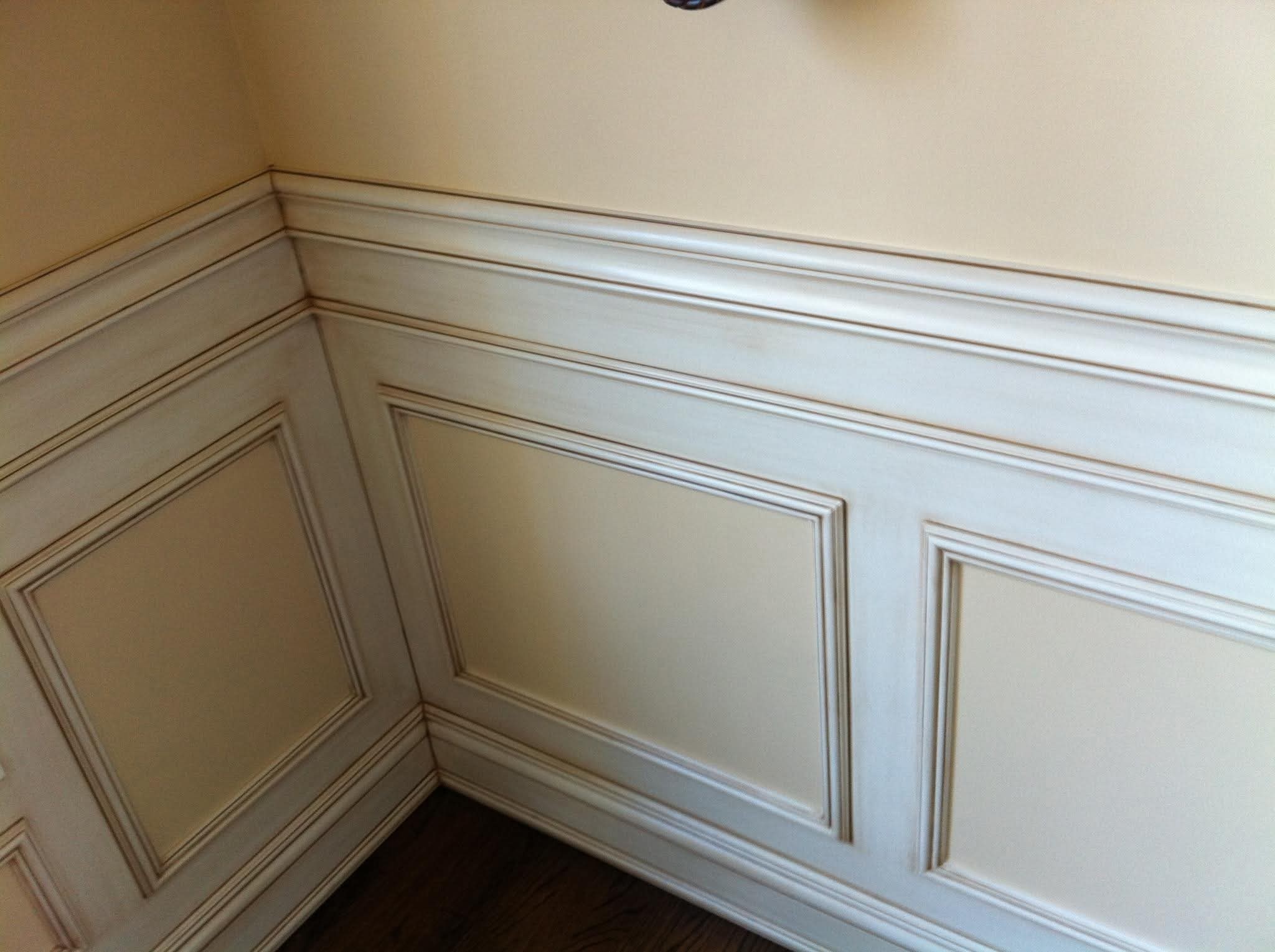 Wainscoting and upper wall painted with antiquing glaze visible on trim.