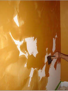 Applying a venetian plaster technique to interior walls with a trowel.