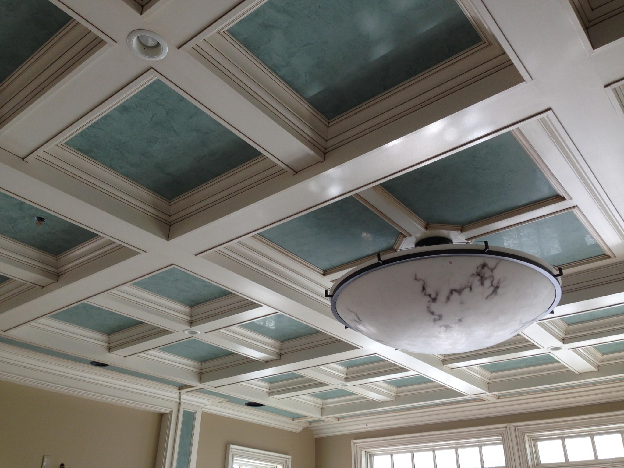 Coffered ceiling with off-white trim and glazed blue-green recessed panels.