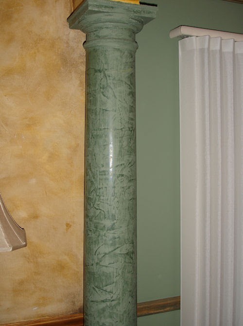 Column with green faux marble finish and adjacent wall with distressed wall finish.