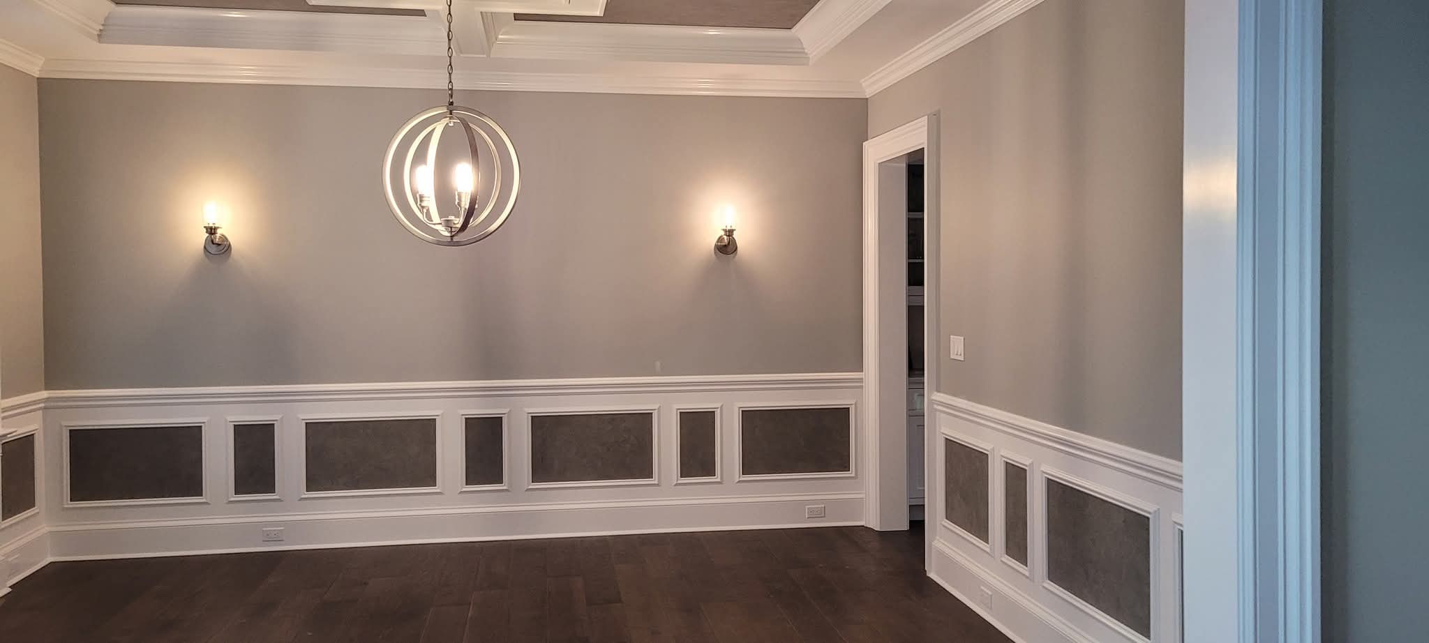 Dining room with newly painted walls, crown molding, and wainscoting.