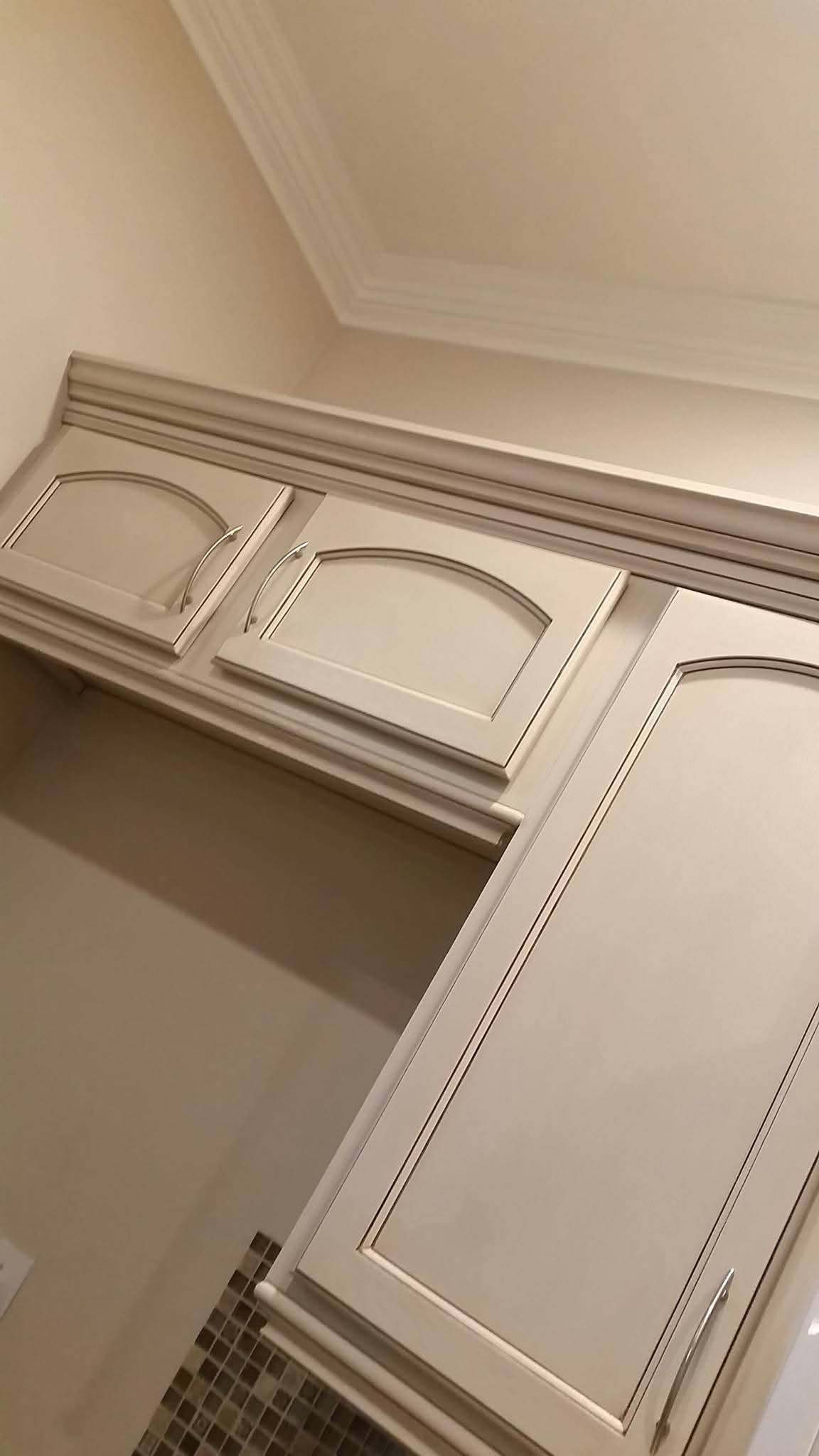 Antiqued cream cabinet doors with darkened moldings