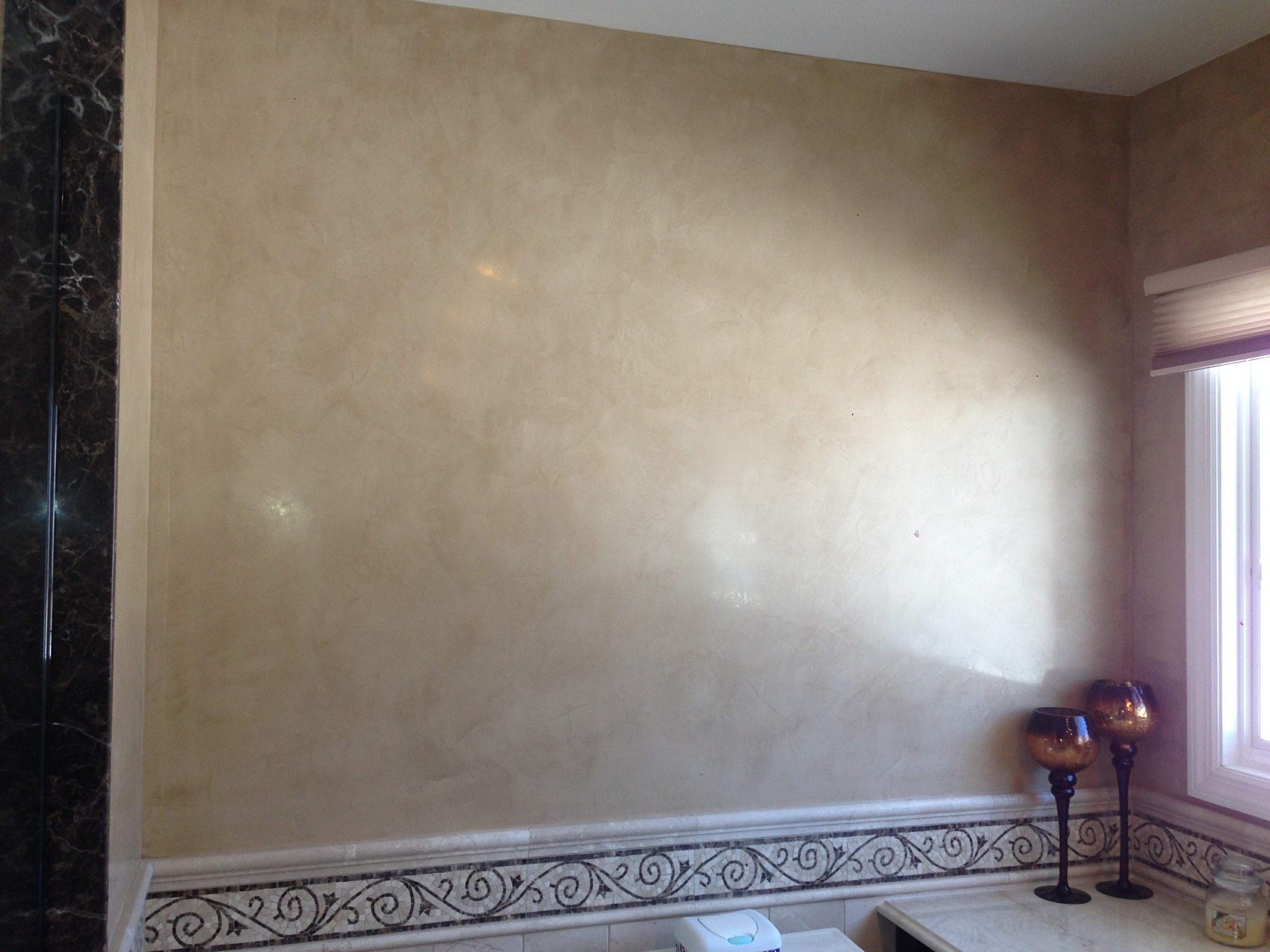Interior walls finished with a venetian plaster technique in a light beige tone.